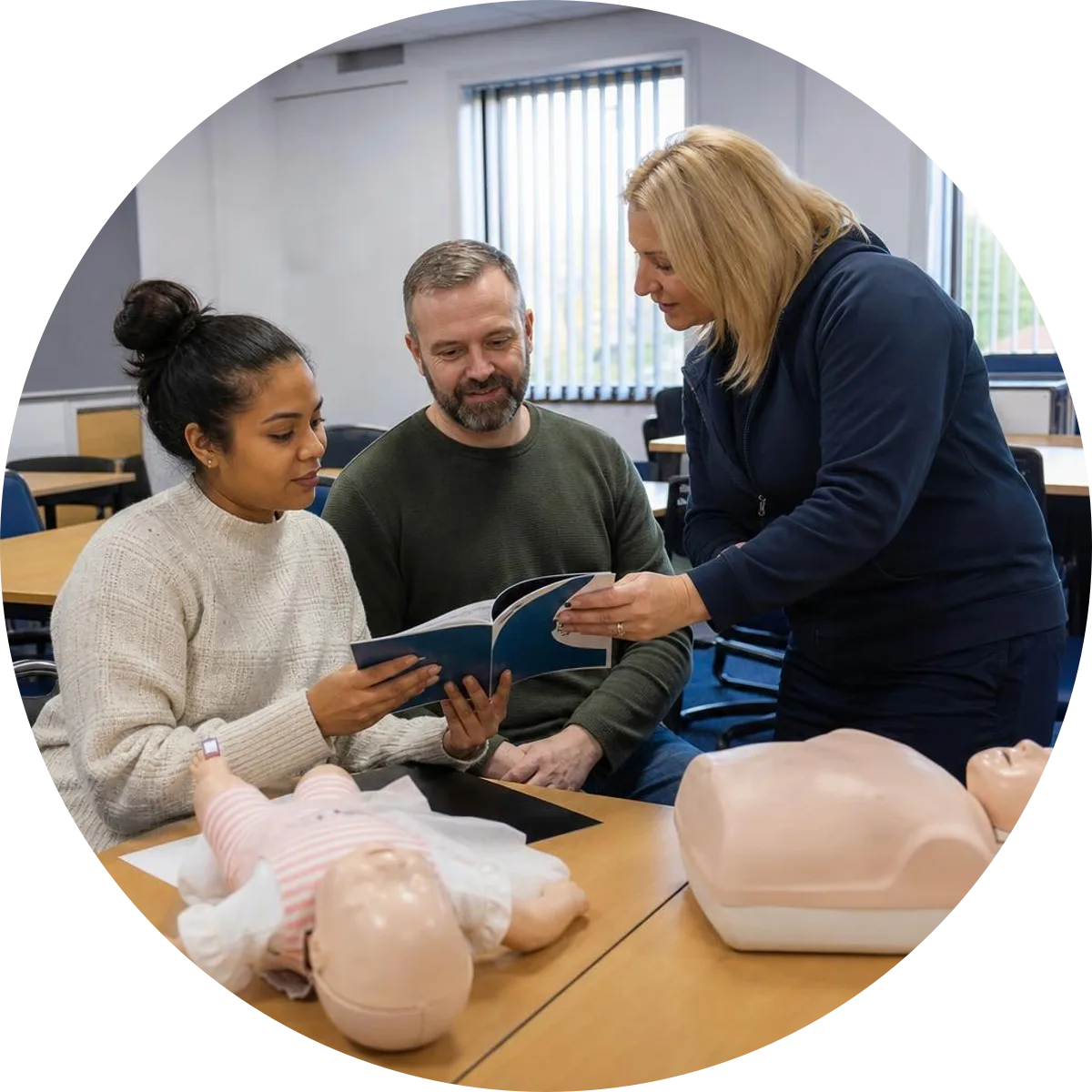 Adult and baby CPR training manikins beside two certificate folders